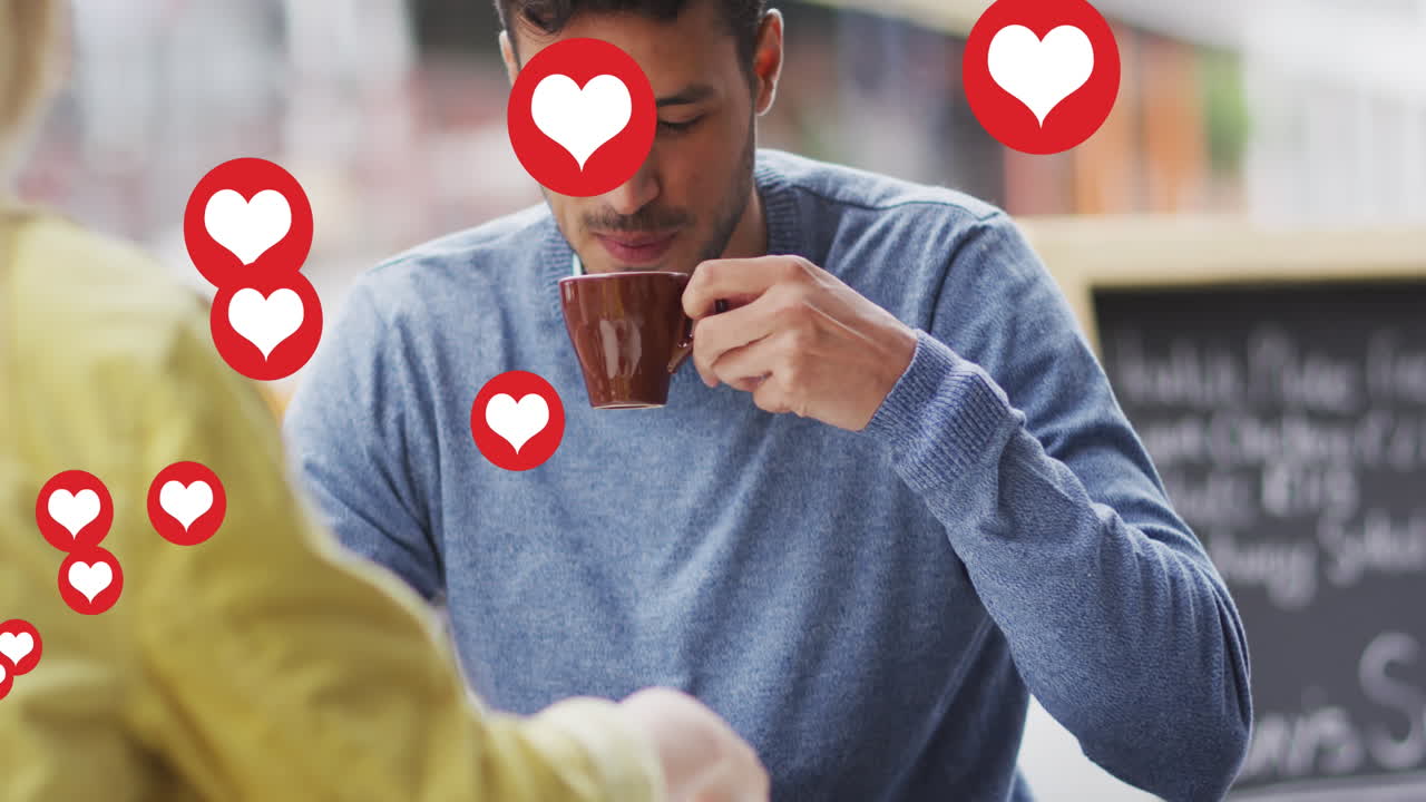 animación de iconos de corazón flotando sobre una feliz pareja caucásica hablando y bebiendo café