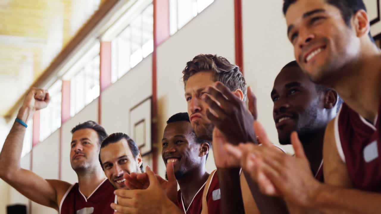 jugador de baloncesto emocionado sentado en el banco y animando