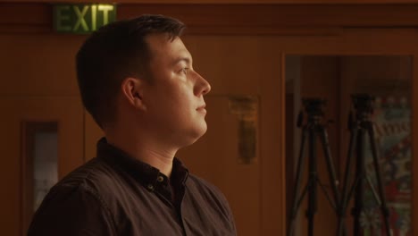 Close up on ethnic male walking and coming to a stop inside a church cathedral sanctuary