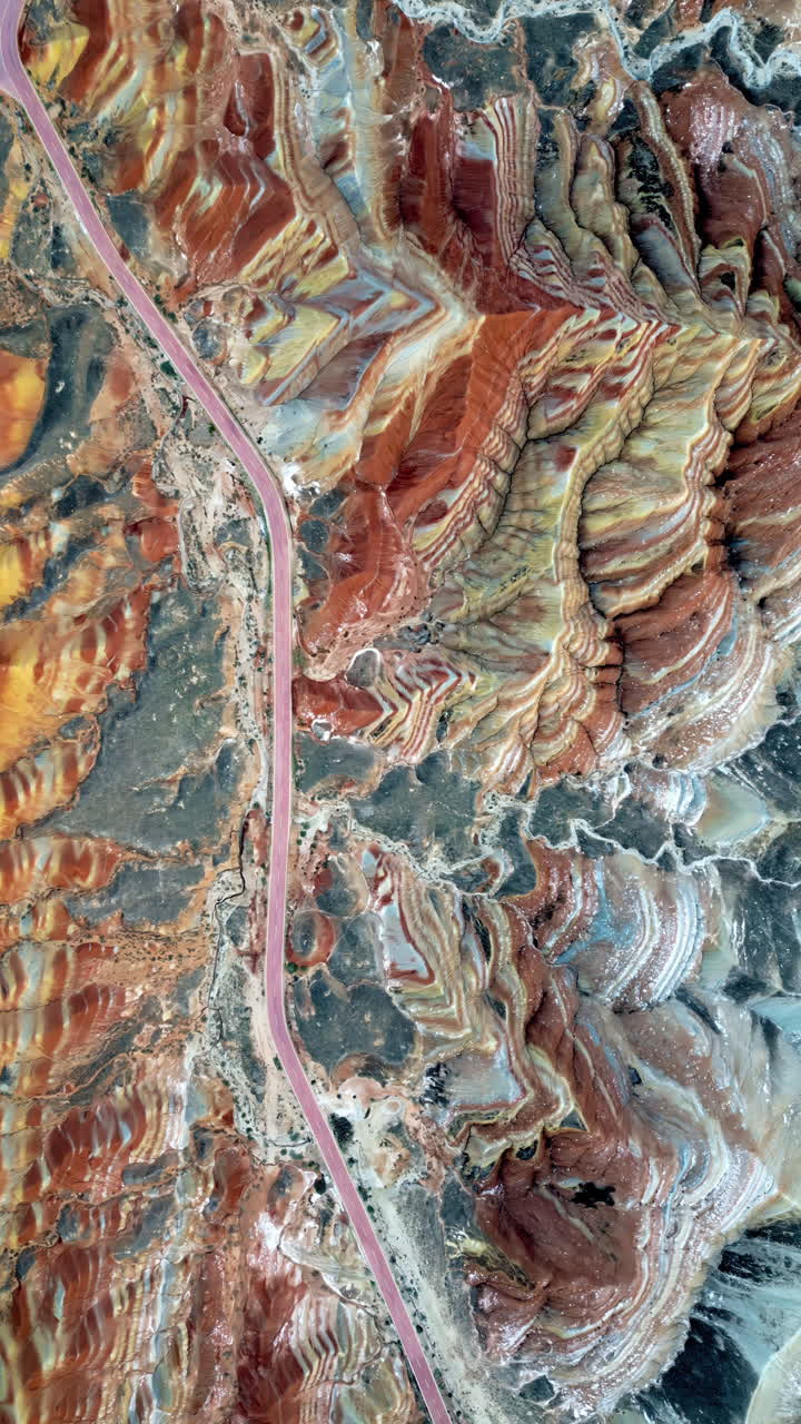 Drönarvy över färggrant skiktade sedimentära bergsformationer i Zhangye Danxia Landform Geological Park i Gansu-provinsen, Kina. Vertikal.