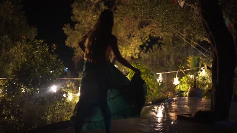 Bella-Mujer-Bailando-Con-Su-Vestido-En-Un-Jardín-Forestal-Iluminado-En-Corfú,-Cámara-Lenta