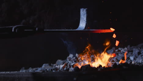 glowing red hot piece of iron removed from metalsmith's furnace, close-up