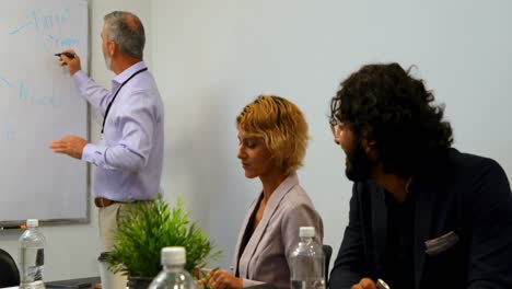 Businessman-giving-presentation-on-whiteboard-in-conference-room-4k