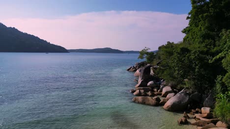 Tropical-paradise-secluded-serene,-sandy-beach-alongside-lush-forest-clear-blue-water