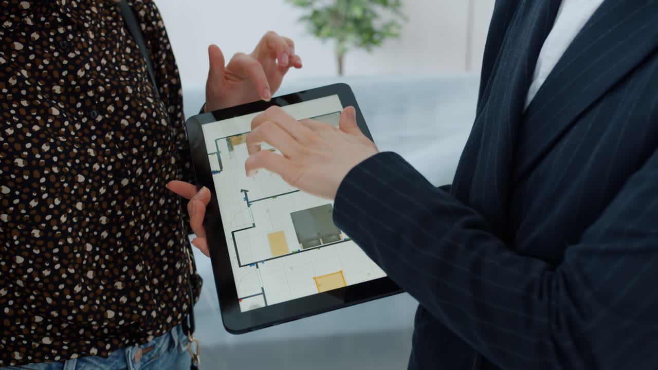 Real Estate Agent Showing Floor Plan on Tablet