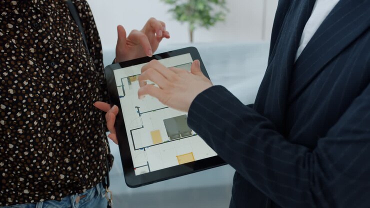 Real Estate Agent Showing Floor Plan on Tablet