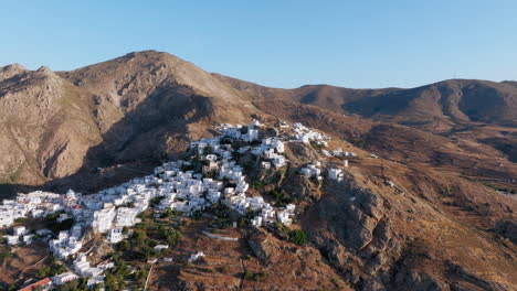 aerial tracking across hilltop chapel and clustered houses of serifos chora at golden hour