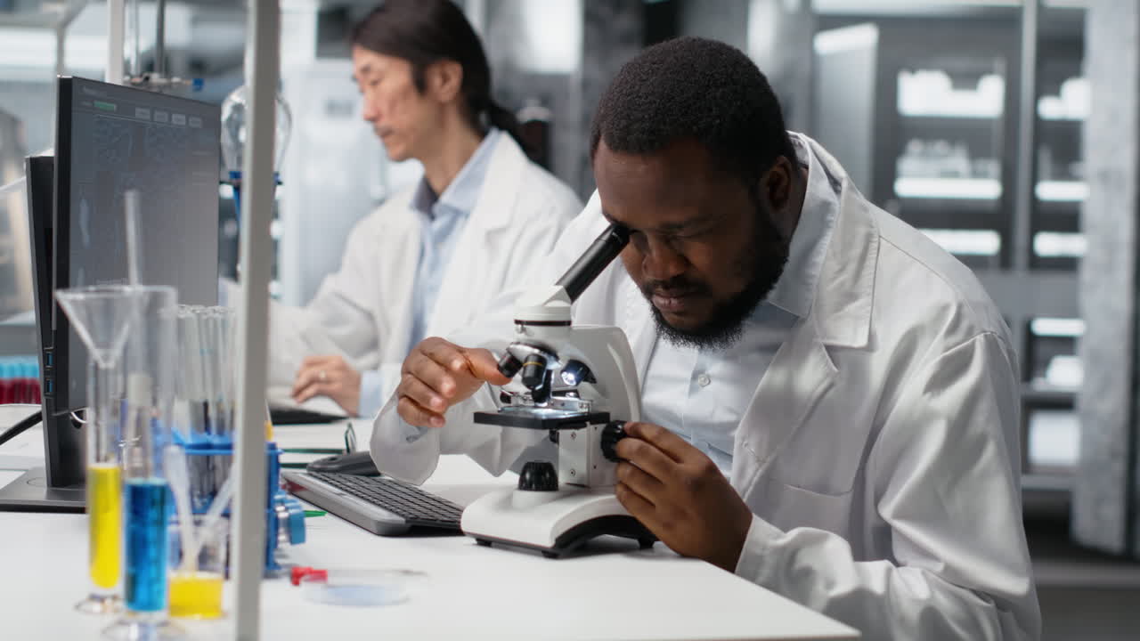 Vertical video Clinical microbiologist in lab using microscope for pathology research