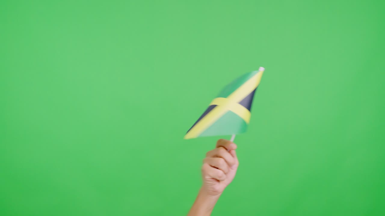 Hand waving a pennant of a jamaican national flag