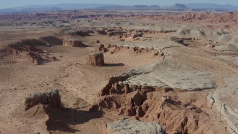 Aerial-shot-flying-over-southern-Utah-desert-with-unique-canyons-and-rock-formations-in-the-distance