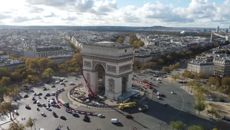 drone view of the arc de triomphe with buildings in the center of paris.