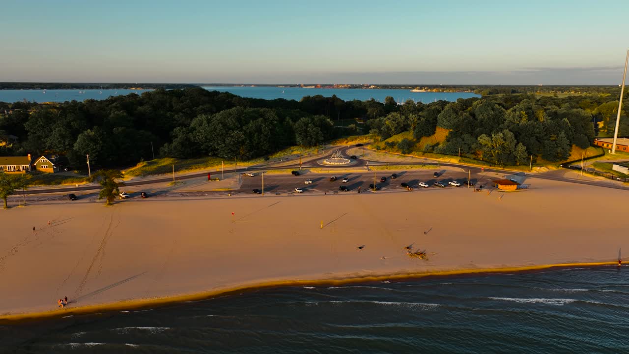 새로운 현대 동상 근처의 해변에서 파도를  ⁇ 고 있습니다.