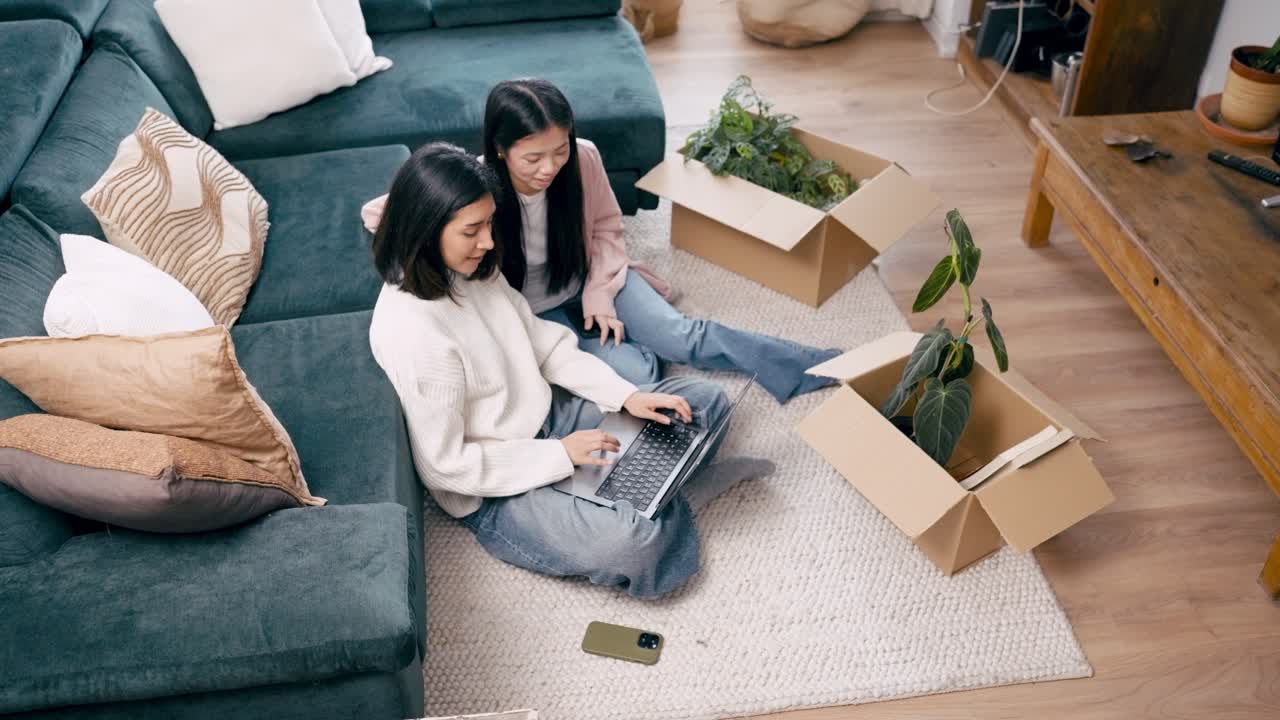 Two Young Women Sitting on Floor Using Laptop at Home