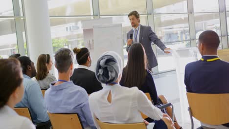 Male-speaker-with-clipboard-speaking-in-the-business-seminar-4k