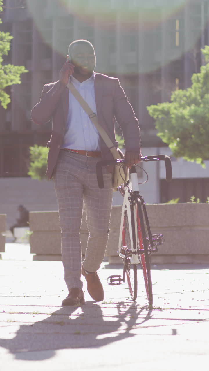 도시에서 아프리카계 미국인 남자의 수직 비디오, 빛에서 자전거를 타고 스마트폰으로 이야기
