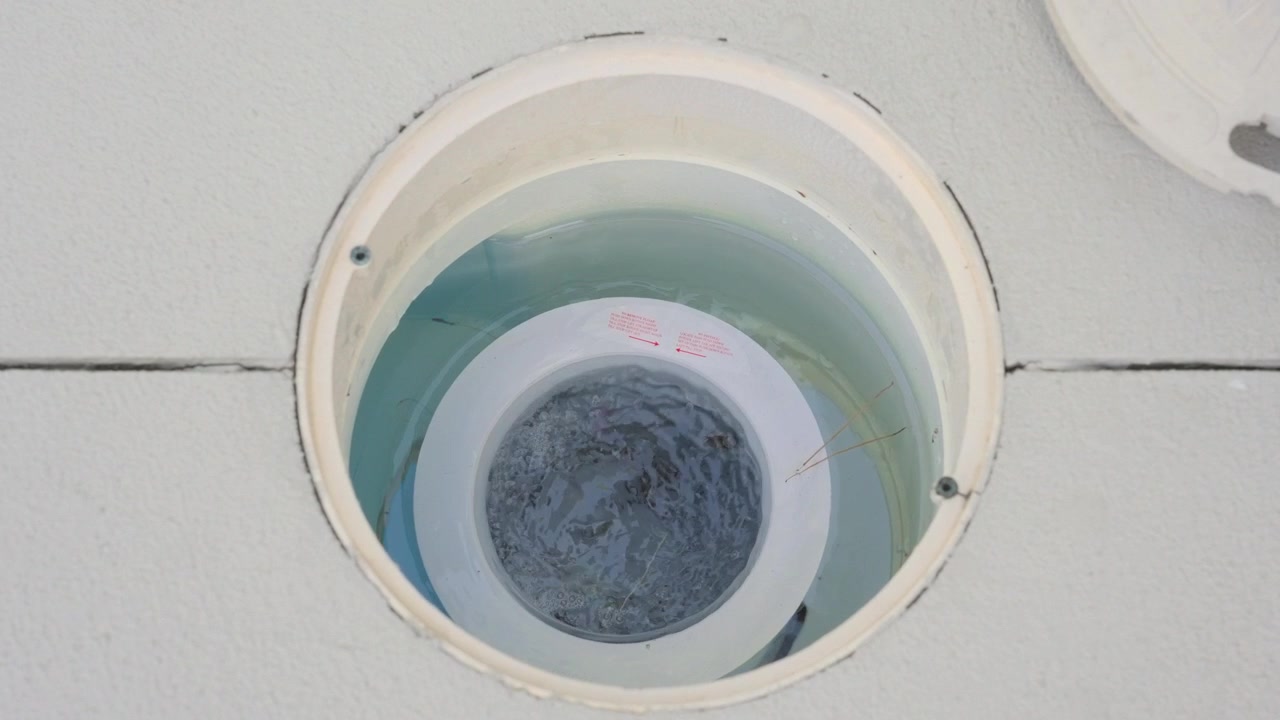 Slow Motion Close Up of a family Pool's filtration and chlorine system.