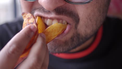 close-up of a man eating potato wedges