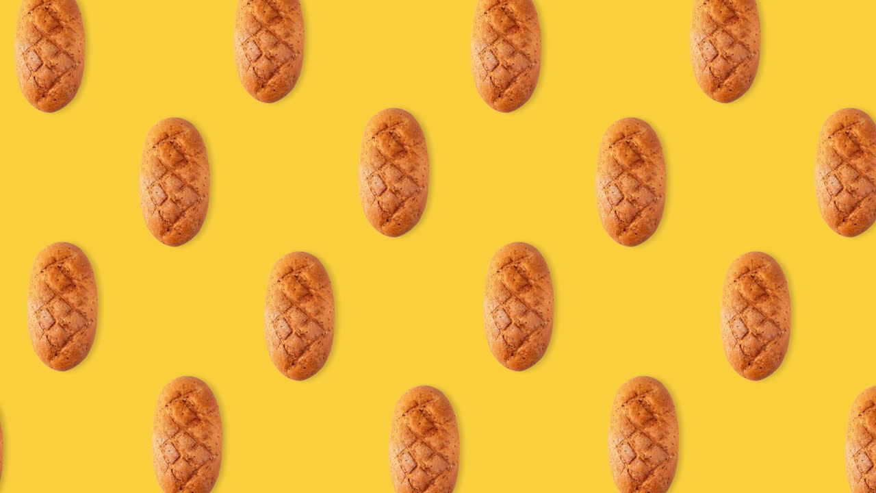 seamless looping animation of a whole diet loafs top view. pattern of bread above a yellow background, copy space