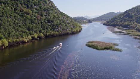 Boat-cruising-at-Lake-skadar-Montenegro-famous-touristic-destination,-aerial