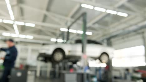 blurred image of car being serviced in a garage