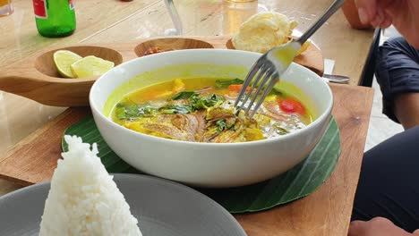 Close-up-of-a-delicious-asian-yellow-fish-curry-in-large-white-bowl-for-dinner-in-a-restaurant