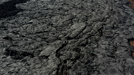 Fly-above-volcanic-landscape.-People-exploring-cooling-lava-stream.-White-smoke-coming-out-from-natural-vent.-Fagradalsfjall-volcano.-Iceland,-2021