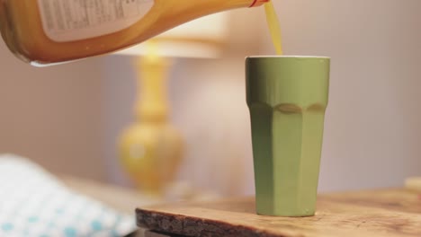 Orangensaft-Wird-In-Eine-Grüne-Tasse-Gegossen