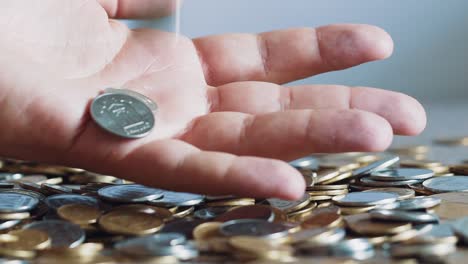 lot of coins in the hands of men, symbolizing wealth. slow motion