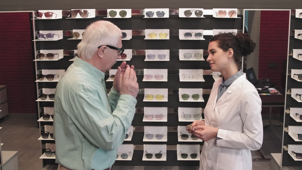 Senior Man Trying On Eyeglasses In Optic Store