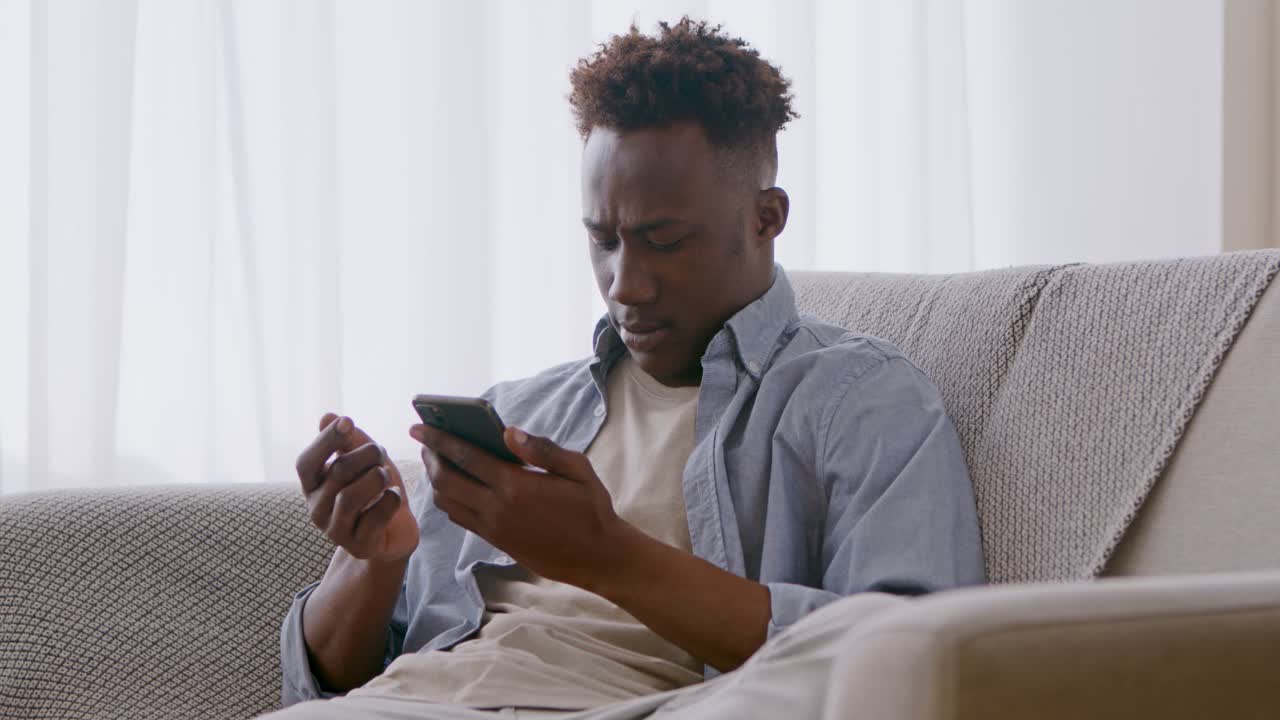 Man using smartphone on a couch