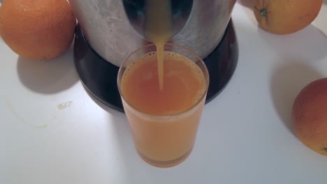 jugo de naranja vertido en vaso sobre mesa blanca