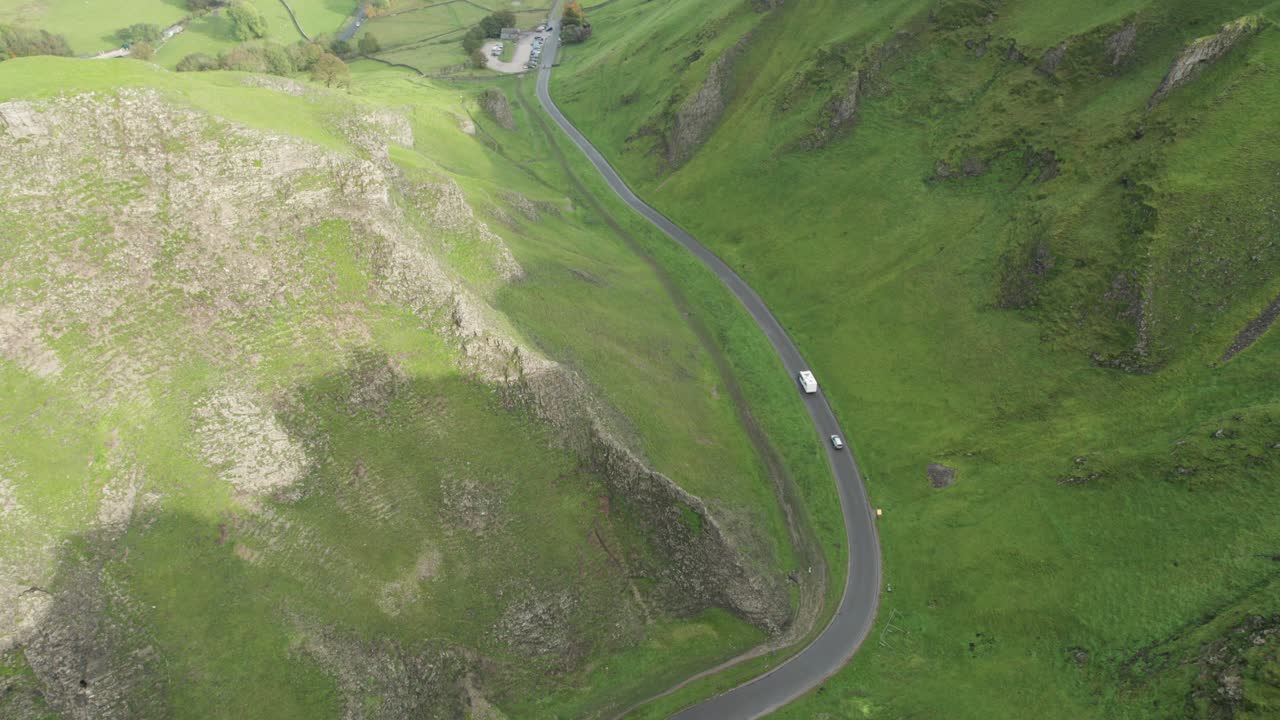 una autocaravana conduciendo por un camino estrecho a través de winnats pass, peak district, inglaterra