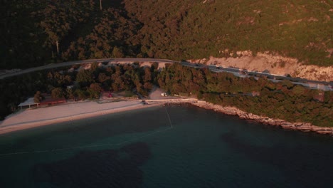 Luz-Roja-Del-Sol-Desde-La-Puesta-De-Sol-Brillando-En-La-Costa-De-Croacia-En-La-Playa-De-Veliki-žal,-Aérea