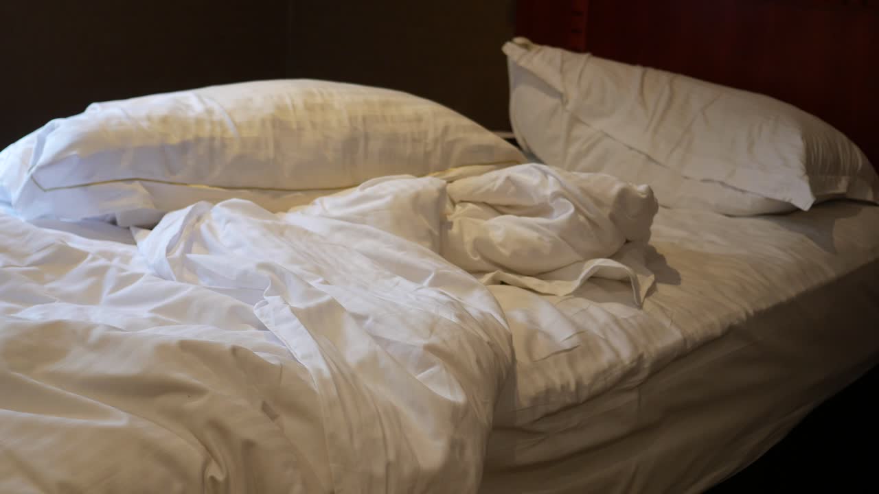 Messy Bed with White Linens and Pillows