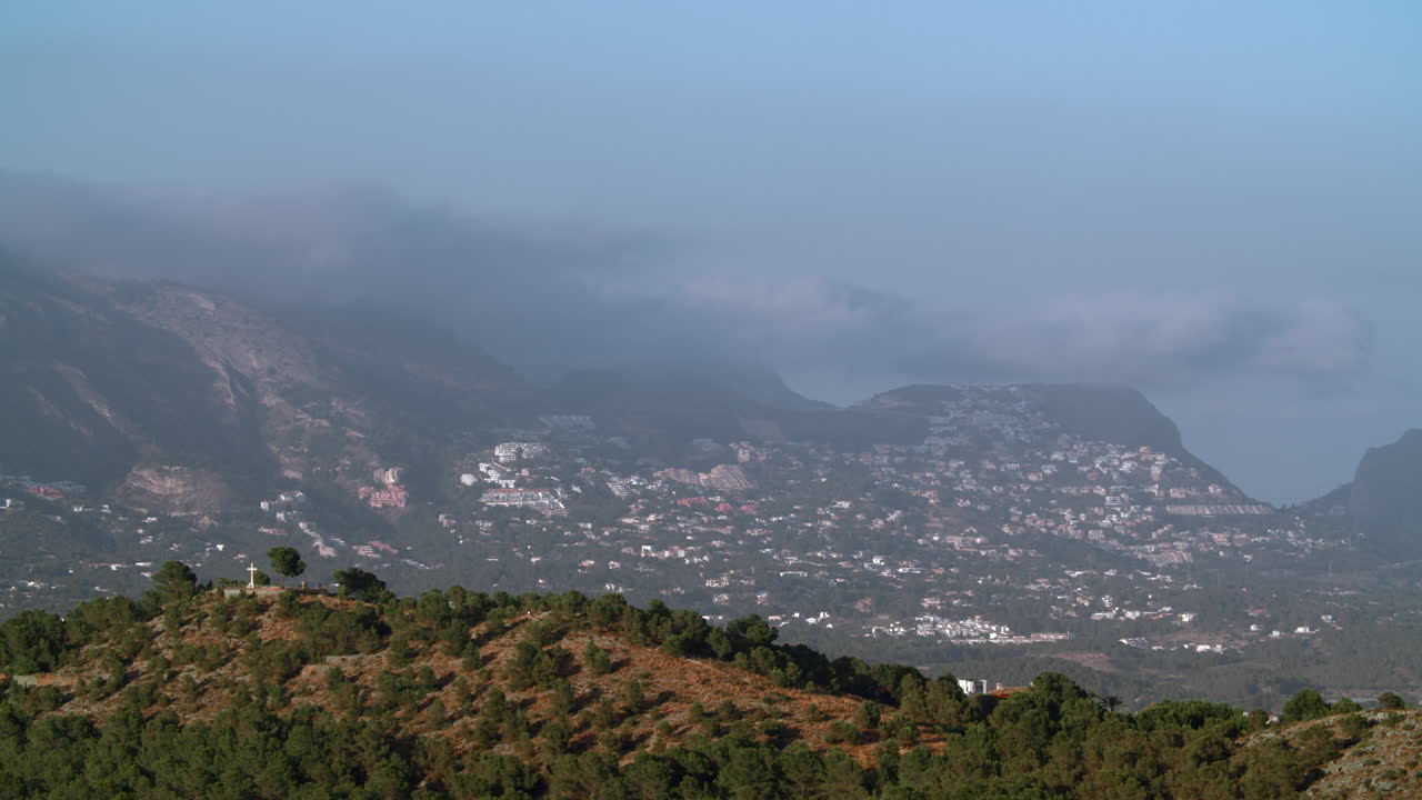 paisaje con ciudad de montaña y nubes de niebla sobre ella españa