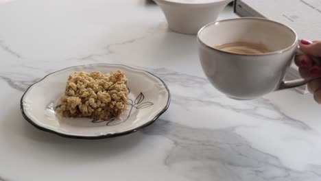 serving coffee with milk next to apple pie desert at table with marble