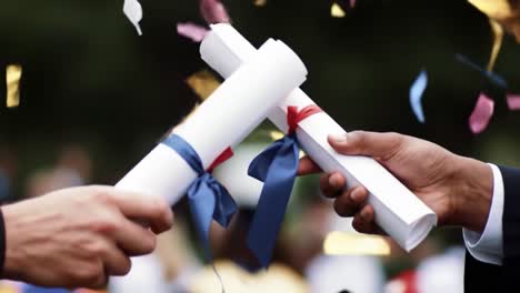 graduates are joyfully exchanging diplomas during a graduation ceremony held outdoors in a spring setting, surrounded by fellow students and family members.