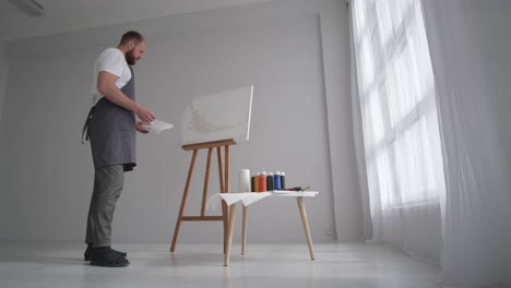 male artist paints a picture with oil paints artist while working in the studio - male artist paints a picture with oil paints, artist while working in the studio, painting an art picture