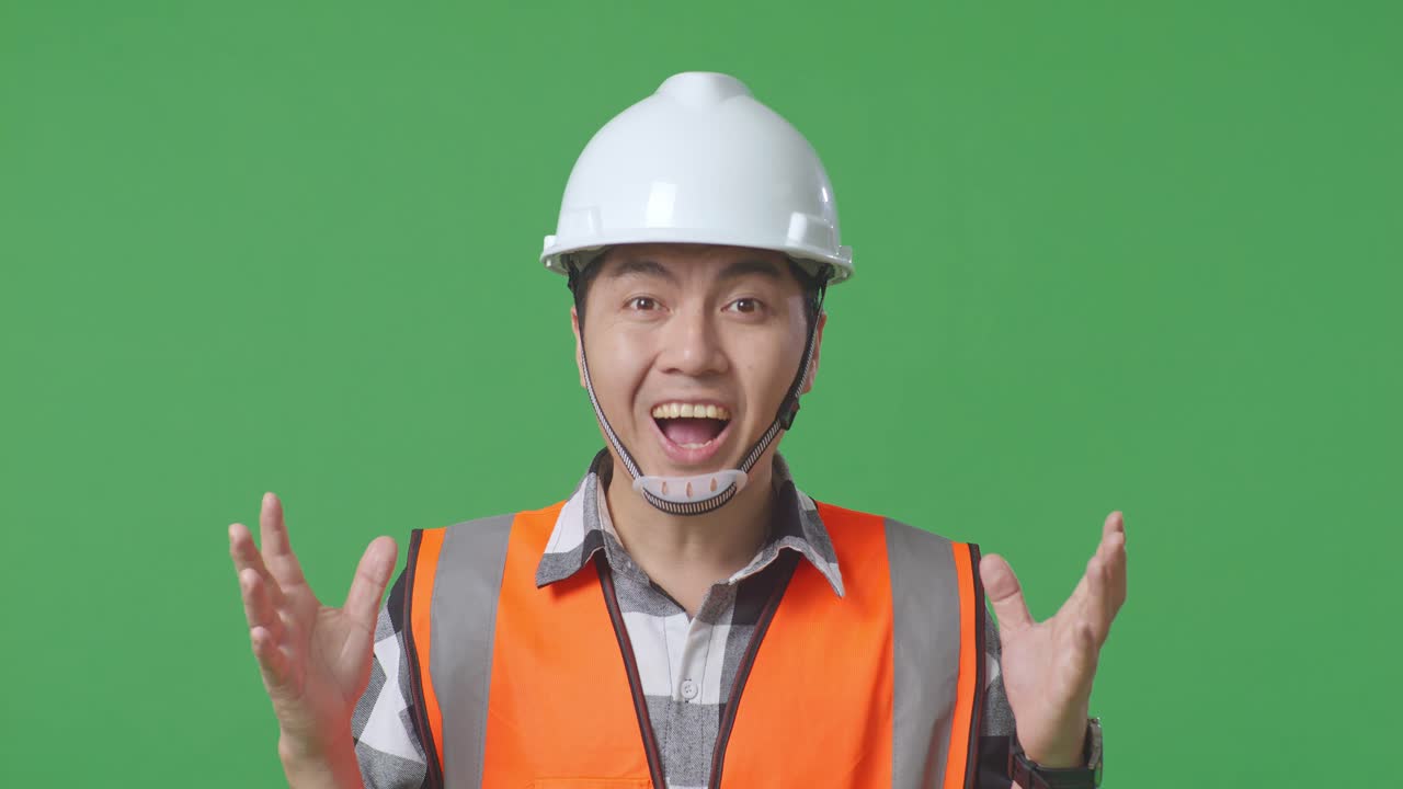 Close Up Of Asian Male Engineer With Safety Helmet Smiling To Camera And Saying Wow While Standing In The Green Screen Background Studio