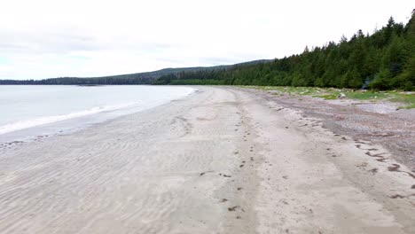 coastal beach along grey bay aerial dolly in shot over sandy shoreline, bc, canada