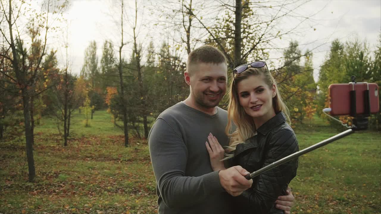 пара делает селфи в осеннем парке.