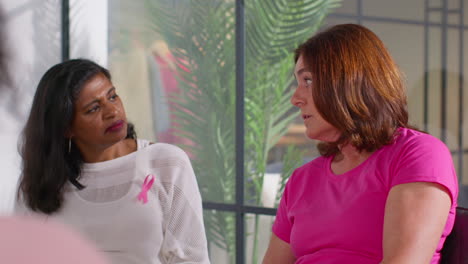 mature woman talking at meeting of therapy support group for breast cancer treatment patients sitting at table 1