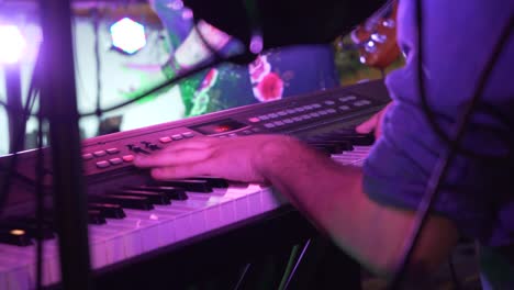 banda tocando en concierto por la noche con teclado tocando los dedos
