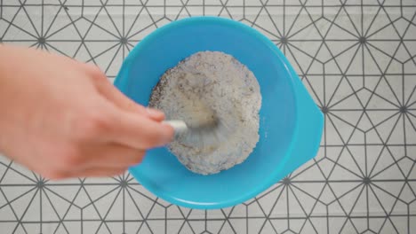 Man-mixing-the-dry-ingredients-for-pie-dough-in-a-blue-bowl