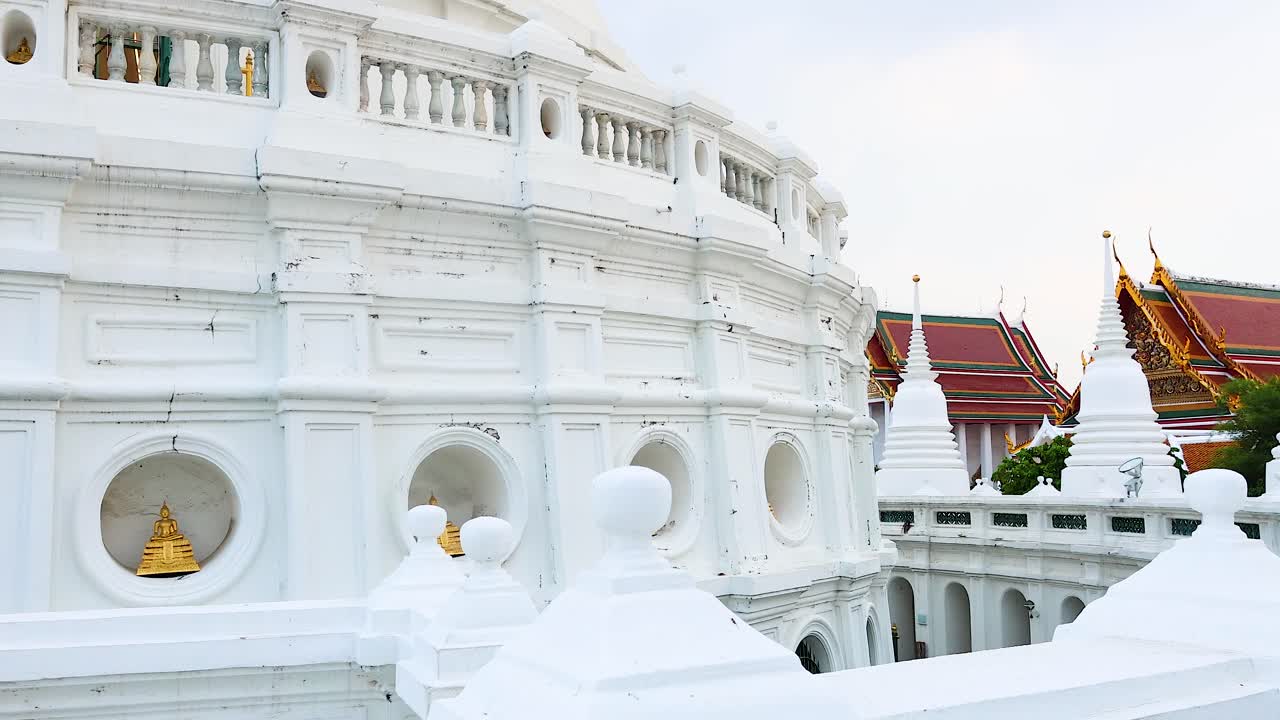 una vista serena de la pagoda blanca de wat prayurawongsawat en bangkok, que muestra una arquitectura intrincada y un entorno pacífico