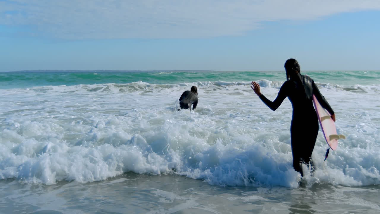una pareja de surfistas disfrutando de las olas 4k