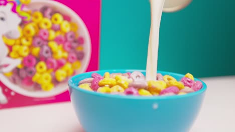 someone pours milk into a bowl of cereal.