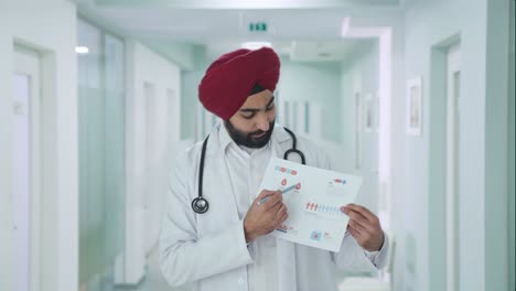 serious sikh indian doctor explaining medical reports to patient