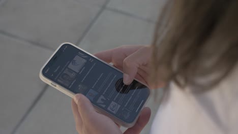 chatain's hair woman who is scrolling on her smartphone
