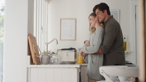 happy pregnant couple hugging proud husband embracing wife holding her belly excited for parentood looking out window thinking of future 4k